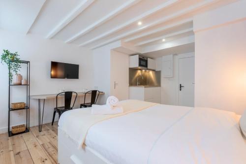- une chambre blanche avec un lit blanc et une table dans l'établissement Lille center bright and functional studio, à Lille