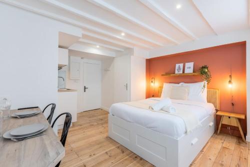 une chambre avec un lit blanc et une table dans l'établissement Lille center bright and functional studio, à Lille