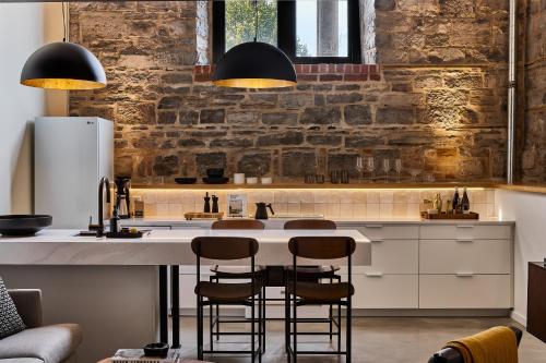 a kitchen with a large white counter with stools at The Smith Hotel in Kingston