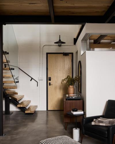 a living room with a wooden door and stairs at The Smith Hotel in Kingston