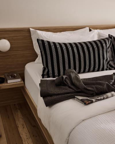 a bed with black and white striped pillows at The Smith Hotel in Kingston