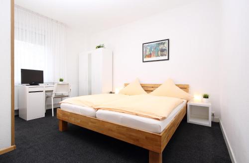 a bedroom with a bed and a desk with a computer at Hotel Garni Schilling in Duisburg