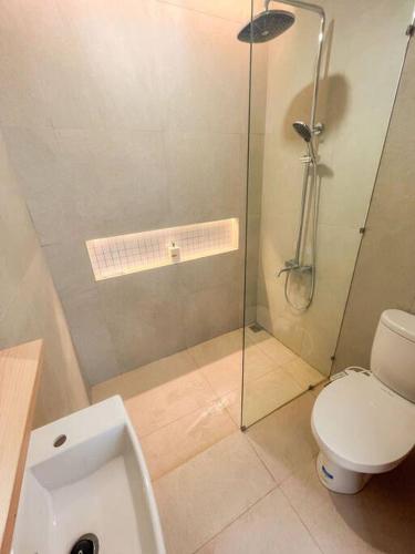 ein Bad mit einem WC und einer Glasdusche in der Unterkunft Villa Kamar Tamu Balecatur 2 in Sleman