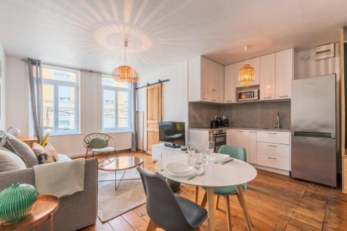 a kitchen and a living room with a table and chairs at Charmant appartement une chambre - hypercentre ! in Lille
