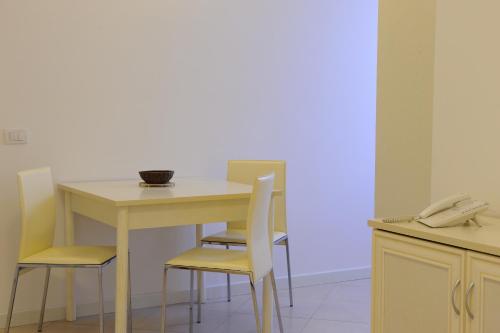 a white table with chairs and a phone on it at Residence Suite Smeraldo in Riccione
