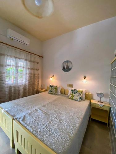a bedroom with a large bed and a window at ZERVOS STUDIOS AND APARTMENTS in Alinda