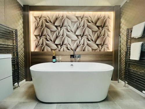 a bath tub in a bathroom with a wall at Enzo's Lodge with Hot Tub in York