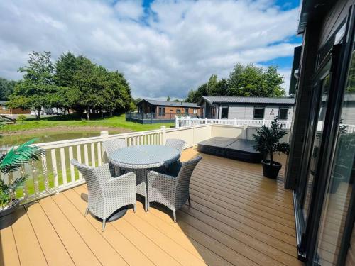 a patio with a table and chairs on a deck at Enzo's Lodge with Hot Tub in York