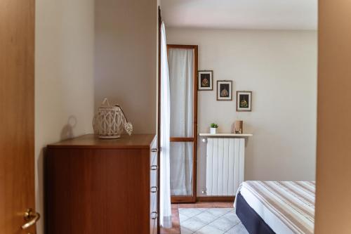 een slaapkamer met een bed en een dressoir naast een bed bij Casa Lisa in Polpenazze del Garda