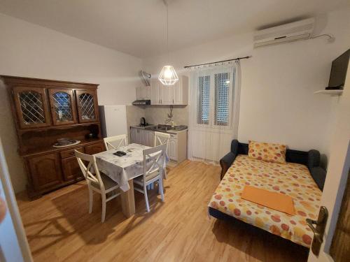 a room with a kitchen and a table and a bed at Kjara Apartments in Tivat