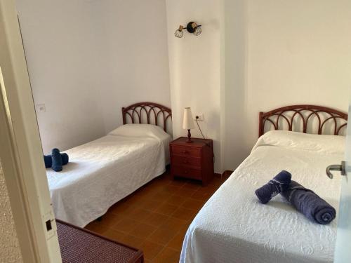 a room with two beds and a table with a lamp at Apartamento frente al Mediterraneo in Torreblanca