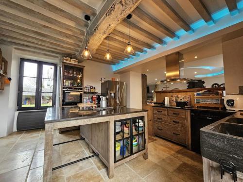 une grande cuisine avec une grande île au milieu dans l'établissement Maison familiale au cœur du D-Day, à Vaux-sur-Aure