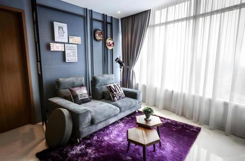 吉隆坡Vortex KLCC apartment by All Asia的客厅配有沙发和紫色地毯