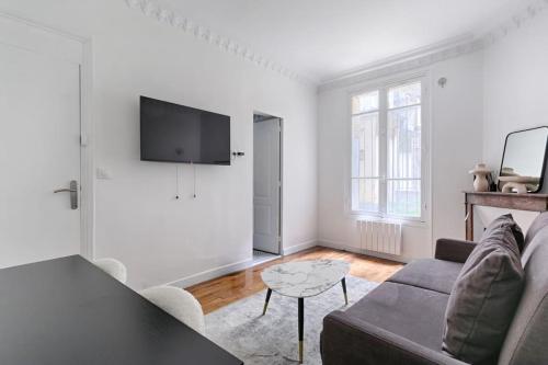 un salon avec un canapé et une télévision dans l'établissement Montmartre/Natier : Cosy Studio 2P, à Paris