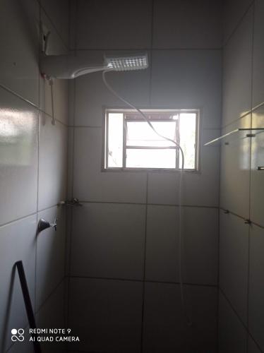 uma casa de banho com um chuveiro e uma janela em Apartamento Aconchegante 4 em Rondonópolis