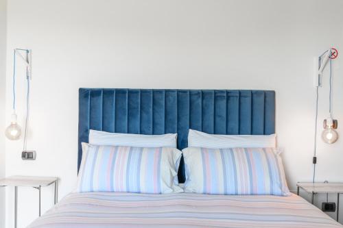 a bed with a blue headboard and white pillows at Villa Rocco Country House in Ozzano Monferrato