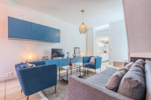 un salon avec des canapés bleus et une télévision dans l'établissement 4 BR & 4 bathroom house close to Parc Barbieux, à Roubaix