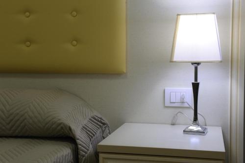a lamp sitting on a table next to a bed at Residence Suite Smeraldo in Riccione