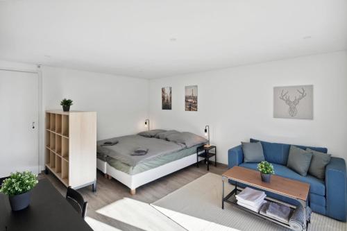 sala de estar con cama y sofá azul en Gemütliche Ferienwohnung direkt an der Skipiste, en Wildhaus