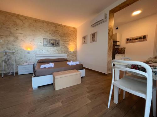 um pequeno quarto com uma cama e uma cadeira em Cefalù Suite em Cefalù