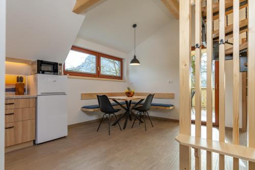 a kitchen and dining room with a table and chairs at Apartment Orehar in Bohinj