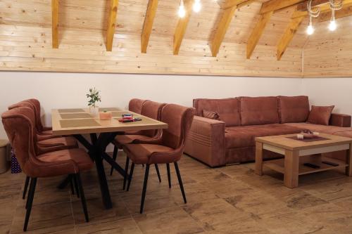 a living room with a couch and a table and chairs at Vila Marija HP in Han Pijesak