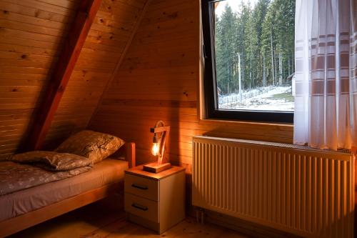 a room with a bed and a window in a cabin at Vila Marija HP in Han Pijesak