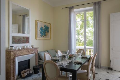 une salle à manger avec une table et une cheminée dans l'établissement Villa Fantaisie, à Menton
