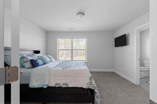 ein Schlafzimmer mit einem Bett mit blauen Kissen und einem Fenster in der Unterkunft The Arches in Lawrenceville