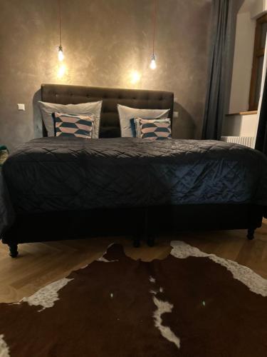 a bedroom with a bed with a black comforter at MARKT LIFE HOME APPARTMENTS in Lutherstadt Wittenberg