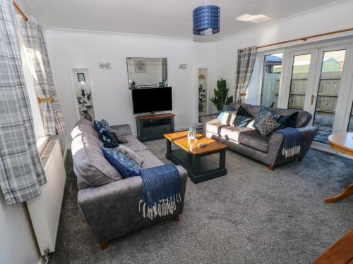 a living room with two couches and a tv at The Old Well Bungalow - Ty Mawr Farm in Cardiff