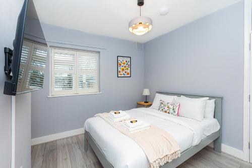 a bedroom with a white bed and a window at Renovated 3BR wgarden in Stratford, 1min to Train in London