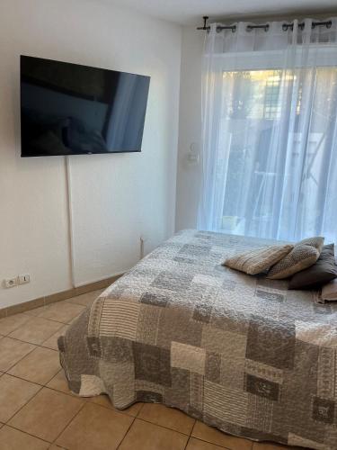 - une chambre avec un lit et une télévision murale dans l'établissement T2 SAUSSET PROCHE DE LA MER, à Sausset-les-Pins