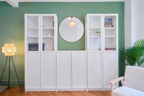 une armoire blanche dans une pièce avec un miroir dans l'établissement Charmante maison 3 chambres avec jardin., à La Madeleine