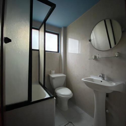 uma casa de banho com um WC, um lavatório e um espelho. em Hotel Yagan Porvenir em Porvenir