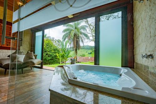 a large tub in a room with a large window at Fazenda Borges in Rio Piracicaba