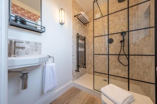 a bathroom with a shower and a sink at The Coach House R 6 in Ringstead
