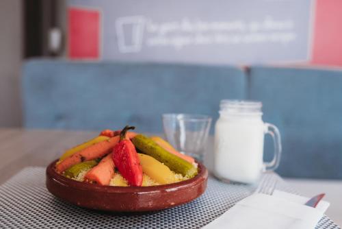 a bowl of fruit on a table with a jar of milk at Ibis Casanearshore in Casablanca