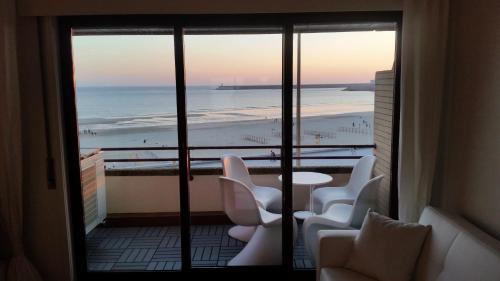a room with a balcony with a view of the beach at Porto Sea Apartments in Matosinhos
