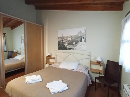 een slaapkamer met een bed met handdoeken erop bij Apartamentos Las Cuadras de Estaños in Muriedas