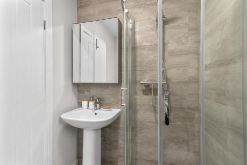 y baño con lavabo y ducha acristalada. en Whitehill House - 3-Bed Home from Home, Sleeps 7, Great for Groups & Workers, FREE Parking & Netflix en Whiston