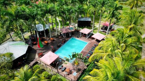 einen Blick über einen Pool mit Palmen in der Unterkunft Plantage Resort Frederiksdorp in Paramaribo