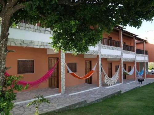 a building with hammocks hanging outside of it at Vila Harmonia in Conde