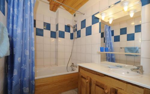 Chalet Le Choucas N°3 في Levassaix: حمام مع حوض وحوض استحمام ودش