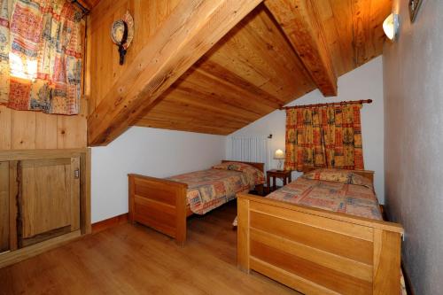 Chalet Le Choucas N°3 في Levassaix: غرفة نوم بسريرين وسقف خشبي