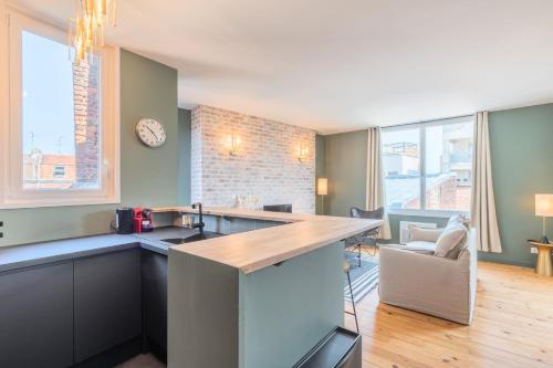 une cuisine avec un comptoir et une horloge au mur dans l'établissement Charming 2 bedroom apartment - Old Lille, à Lille