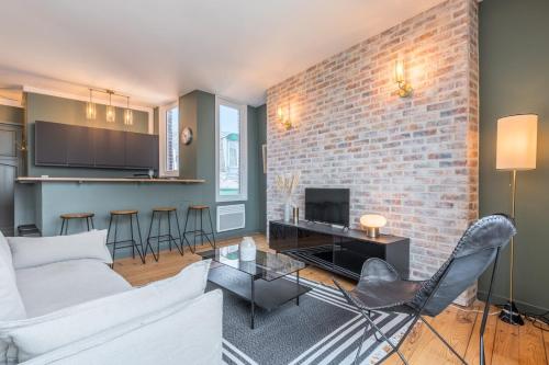 - un salon avec un canapé blanc et un mur en briques dans l'établissement Charming 2 bedroom apartment - Old Lille, à Lille
