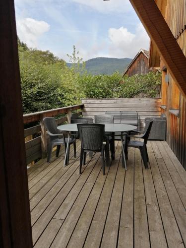 une terrasse en bois avec des tables et des chaises. dans l'établissement Les gîtes du Falimont, à Stosswihr