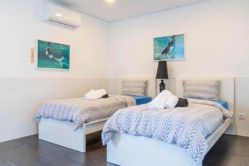 twee bedden in een kamer met witte muren bij Batalha Golf Villa in Pico da Pedra
