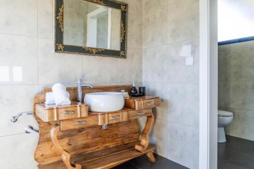 a bathroom with a sink and a mirror on the wall at Batalha Golf Villa in Pico da Pedra